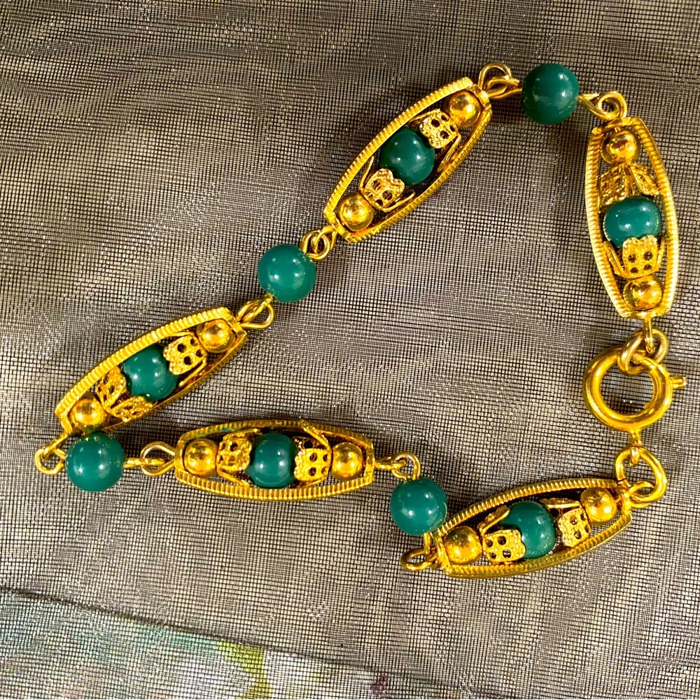 Gold tone bracelet with green beads